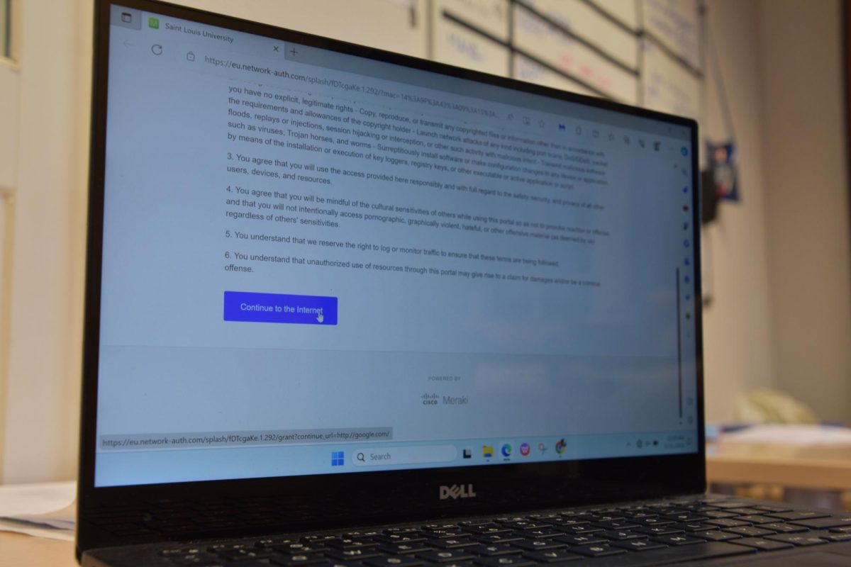 A student laptop shows the confirmation button to accept the terms and conditions to use SLU Madrid Wi-Fi on campus.