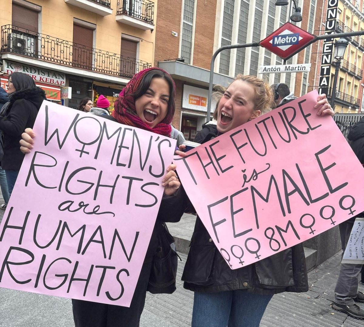 Two members of the Human Rights Club ready their signs before the start of the demonstration at Plaza de Antón Martín.