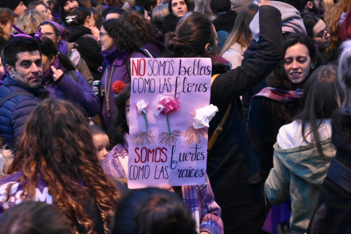 A sign at the International Women's Day March in Madrid reads, "We are not beautiful like flowers, we are strong like the roots."