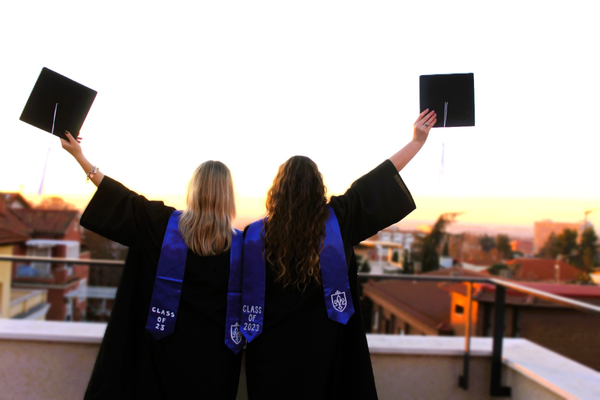 Evie Stancil and Jackie Amacker pose on the San Ignacio Hall rooftop following the 2023 winter graduation ceremony. 