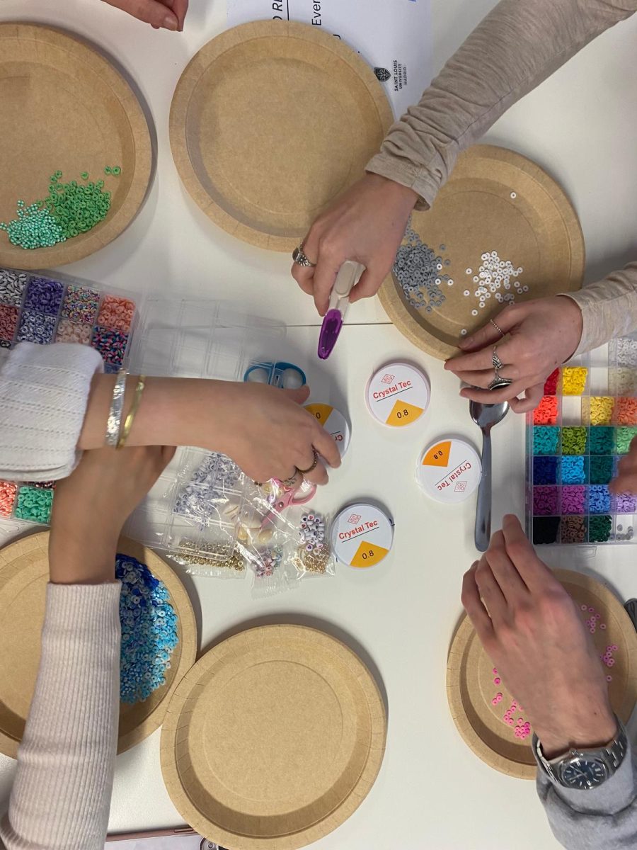 Club members making friendship bracelets for the USA girl scouts overseas