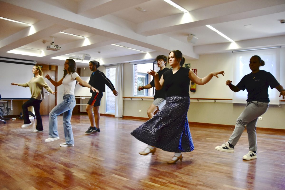 Students participating in a weekly meeting perform a choreographed salsa routine.