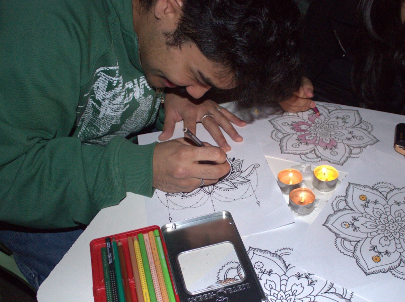 A student collars a rangoli design at the Diwali lights celebration.