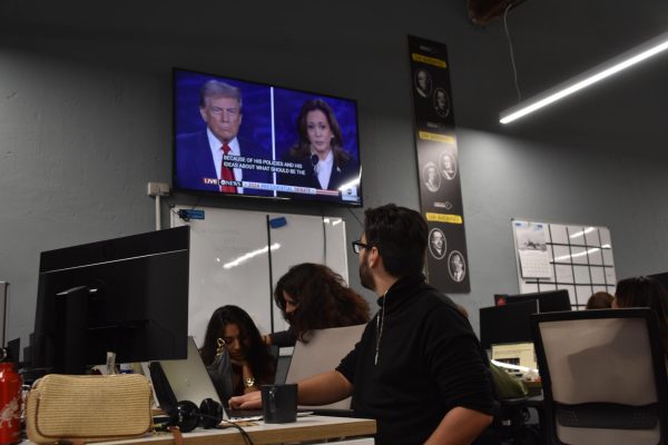 A student looks up at the TV screen in the Newtral news room at the beginning of the debate.