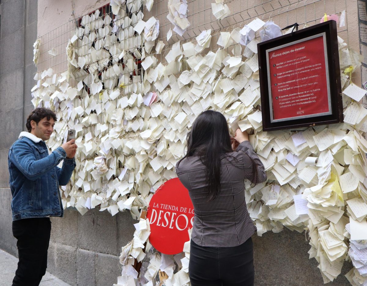 Another couple is seen outside the shop sharing an intimate moment as the boyfriend photographs his girlfriend hanging her wish on the wall. 