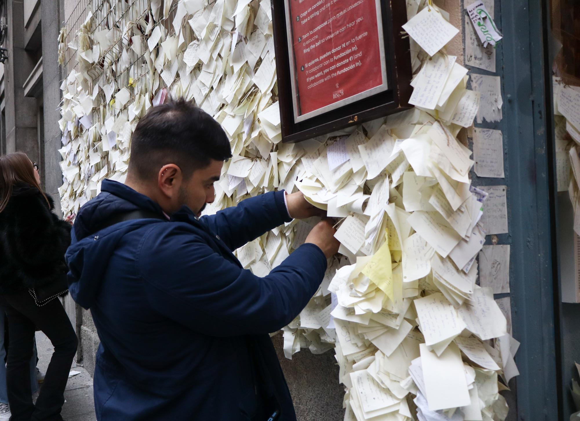 Andrés Cabrera ties a wish to the wall at La Tienda de los Deseos after visiting with his girlfriend. He noted that the visit brought a newfound sense of positivity into his day.