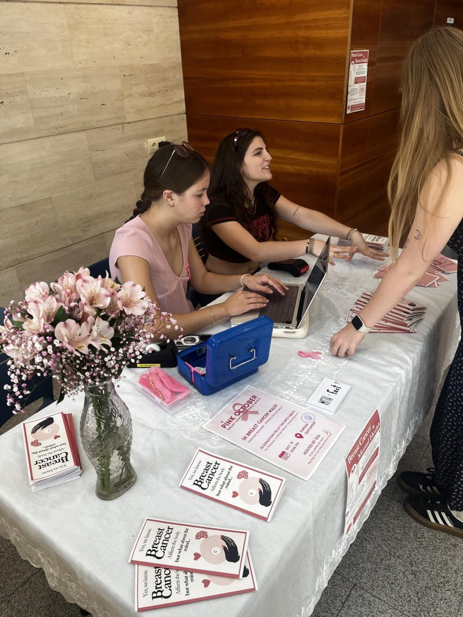 Students hand out educational leaflets and sign up participants for the 5k breast cancer walk in October.